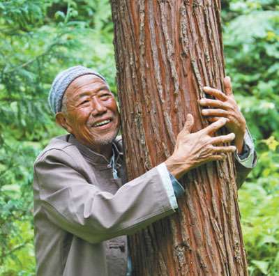 在八五林场里，刘安国像爱自己的孩子一样拥抱树木。.jpg