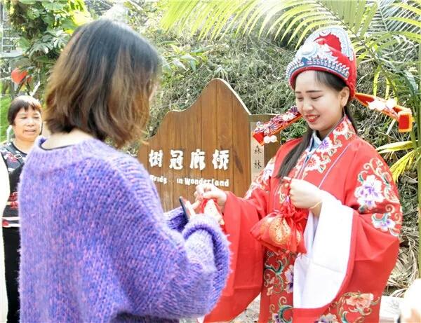 美女扮“财神”，引来游客争相合影，一天上千次直言累得笑不出